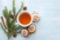 A cup of tea with fragrant honey Christmas gingerbreads with glaze and nuts, with Christmas tree branches and spices