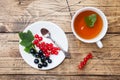 Cup of tea and fresh black and red currant berries on wooden table. Copy space Royalty Free Stock Photo