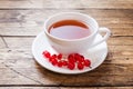 Cup of tea and fresh red currant berries on wooden table. Copy space Royalty Free Stock Photo