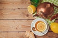 Cup of tea with ginger, lemon and tea pot on wooden table. View from above