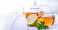 Cup of tea, glass teapot, mint and lemon on wooden table Royalty Free Stock Photo