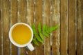 A cup of tea with green leaf on wooden table