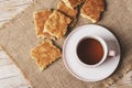 A cup of tea and homemade biscuits on sackcloth napkin on wooden table, top view Royalty Free Stock Photo