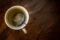 Cup of Tea with infuser in hot smoky water with green tea, mint herbs and honey on a dark wooden background Royalty Free Stock Photo