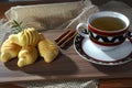 Cup with tea inside, lemongrass, fine herbs cinnamon, baked cheese biscuit on the wooden table