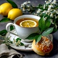Cup of tea with lemon and buns with sesame seeds on a gray background Royalty Free Stock Photo