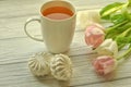 A cup of tea with lemon, fresh tulips and appetizing sweets Royalty Free Stock Photo