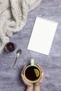 Cup of tea with lemon in hands, knitted scarf, raspberry jam, spoon and notepad near, at gray background Royalty Free Stock Photo
