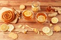 Cup of tea with lemon, honey, ginger root ingredients and sweet cinnamon bun on wooden table. Natural medicine concept Royalty Free Stock Photo