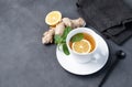 Cup of tea with lemon and mint on a dark background. The concept of a healthy drink for immunity with ginger and herbs. Diet and Royalty Free Stock Photo