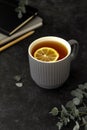 Cup of tea with lemon slice, dark background