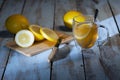 Cup of tea with a lemon slice next to a cutting board with a sliced lemon and a knife Royalty Free Stock Photo