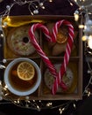 cup with tea and lemon slices, cookies, luminous garlands, lollipops folded in the shape of a heart Royalty Free Stock Photo