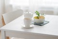A cup of tea with lemon and a teapot on a white table against the background of a kitchen window Royalty Free Stock Photo