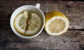 A cup of tea with lemon on wooden background