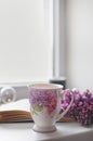 A cup with lilac flowers. Background composition. Romantic atmosphere.