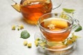 Cup of tea and linden blossom on grey table. Space for text Royalty Free Stock Photo