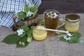 A cup of tea with linden and jasmine flowers and two jars of honey