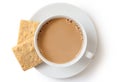 A cup of tea with milk and two square shortbread biscuits isolated on white from above. White ceramic cup and saucer. Royalty Free Stock Photo