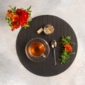 A cup of tea next to a bouquet of marigolds. Morning still life, tea time. Flat lay Royalty Free Stock Photo