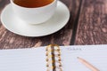 Cup of tea with a notebook and pencil