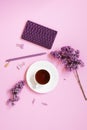 A cup of tea, notebooks, a pen, a bouquet of lilacs on a purple background. Purple spring flowers. Composition for a blogger. or