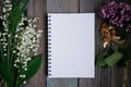 a Cup of tea, nuts, lilacs and a notebook on a wooden table Royalty Free Stock Photo