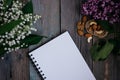 a Cup of tea, nuts, lilacs and a notebook on a wooden table Royalty Free Stock Photo