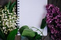 a Cup of tea, nuts, lilacs and a notebook on a wooden table Royalty Free Stock Photo