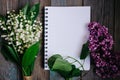 a Cup of tea, nuts, lilacs and a notebook on a wooden table Royalty Free Stock Photo