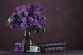 Cup of tea and old books near boquet of lilac flowers Royalty Free Stock Photo