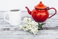 Cup of tea and old red teapot on vintage wooden table with branch of lilac Royalty Free Stock Photo