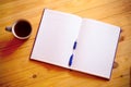 Cup of tea, pen, opened organizer on wooden background