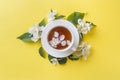 Cup of tea with petals of Jasmine flowers on a bright yellow background. Copy space Royalty Free Stock Photo