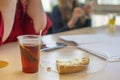 A cup of tea and a piece of cake are lying on the office table near the two dining girls Royalty Free Stock Photo