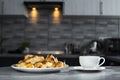 A cup of tea with a plate of croissants on the kitchen table. dessert side view. morning coffee with sweets. recipe of dish