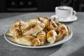 A cup of tea with a plate of croissants on the kitchen table. dessert side view. morning coffee with sweets. recipe of dish