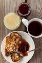 Cup of tea, plate of pancakes, jam, honey