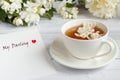 Cup of tea, pouring honey from a spoon in a jar, Jasmine flowers on a light wooden background. Copy space. Royalty Free Stock Photo