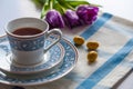 Cup of tea with purple spring tuplis and bright yellow chocolate eatser eggs Royalty Free Stock Photo