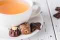 Cup of tea with raw handmade chocolate candies on white wooden background Royalty Free Stock Photo