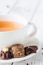 Cup of tea with raw handmade chocolate candies on white wooden table Royalty Free Stock Photo