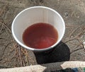 a cup of tea on the sand with lots of litter around it