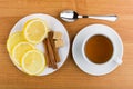 Cup of tea, saucer with pieces of lemon, cinnamon sticks Royalty Free Stock Photo