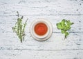 Cup of tea on a saucer with a set of herbal tea thyme, mint, lemon grass wooden rustic background top view close up