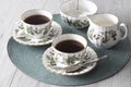 Cup of tea on saucer with teaspoon milk jug and sugar bowl on a green placemat