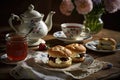 A cup of tea with scones and jam and cream.