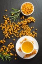 Cup of tea with sea buckthorn and bowl with sea buckthorn oil Royalty Free Stock Photo