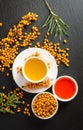 Cup of tea with sea buckthorn and bowl with sea buckthorn oil Royalty Free Stock Photo