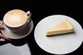 Cup of tea and slice of cheesecake on white plate on table Royalty Free Stock Photo